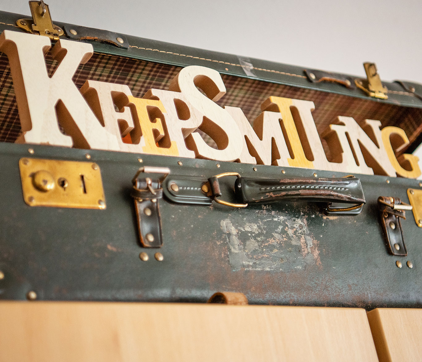 Ein Koffer mit dem Schriftzug Keep Smiling steht in der Einrichtung der Seniorenpflege.