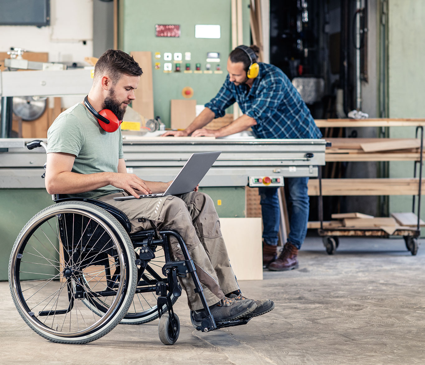 Ein Mann im Rollstuhl arbeitet in einer Tischlerei.